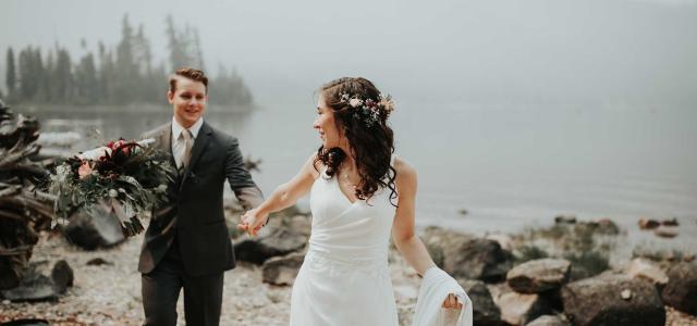 Married couple in front of lake.